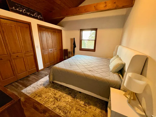 a bedroom with a bed and wooden floor