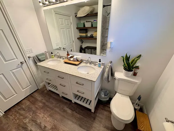 a bathroom with a granite countertop toilet sink and mirror