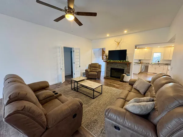a living room with furniture a flat screen tv and a fireplace