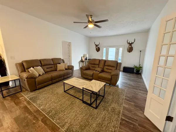a living room with furniture and a wooden floor