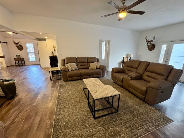 a living room with furniture and a wooden floor