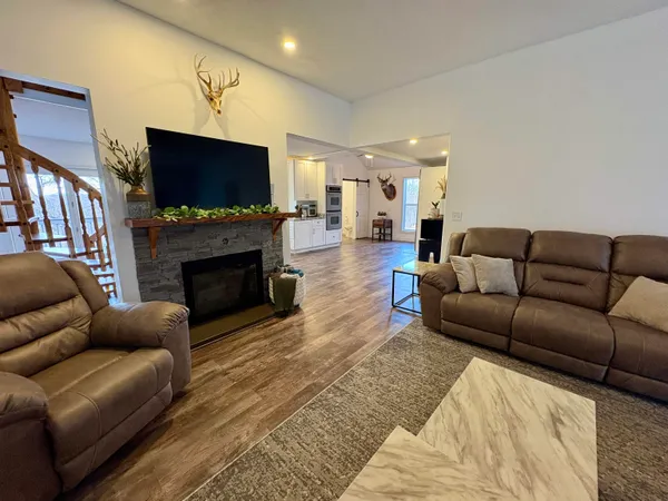a living room with furniture a flat screen tv and a fireplace