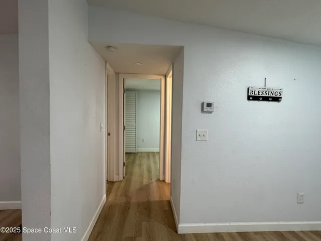 a view of a hallway with wooden floor