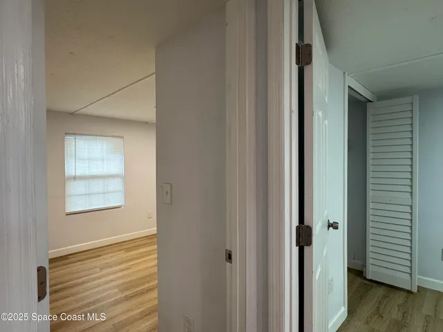 a view of a hallway with wooden floor