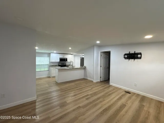 a kitchen with granite countertop a sink cabinets and stainless steel appliances