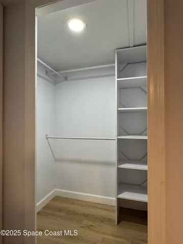 a view of walk in closet with empty racks