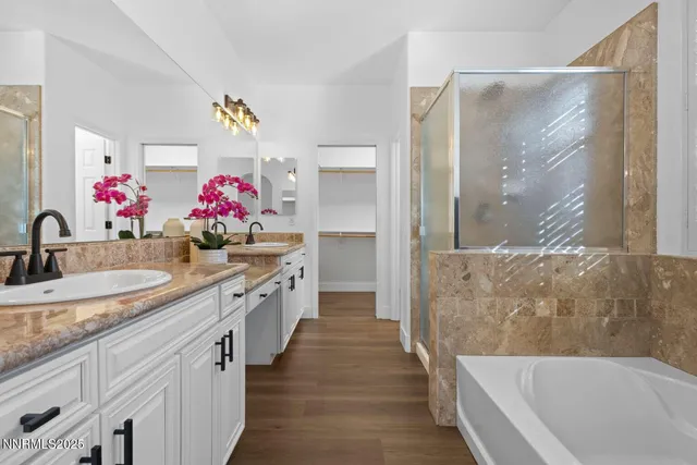 a bathroom with a granite countertop tub sink and mirror