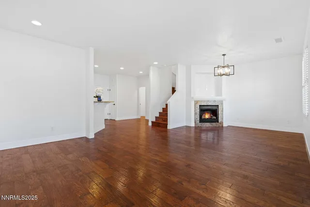 a view of empty room with wooden floor and fireplace
