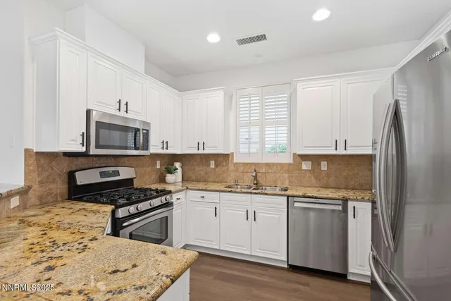 a kitchen with stainless steel appliances a sink stove and refrigerator