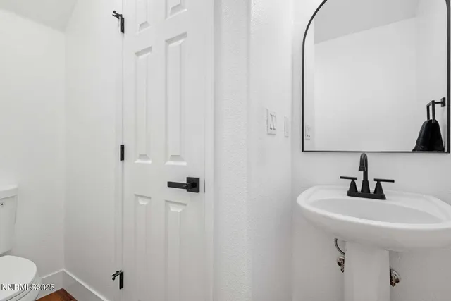 a bathroom with a sink a toilet and shower curtain