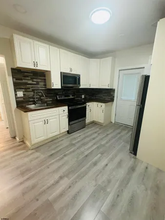 a kitchen with granite countertop a refrigerator sink and cabinets