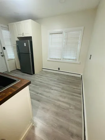 a view of a refrigerator in kitchen and wooden floor