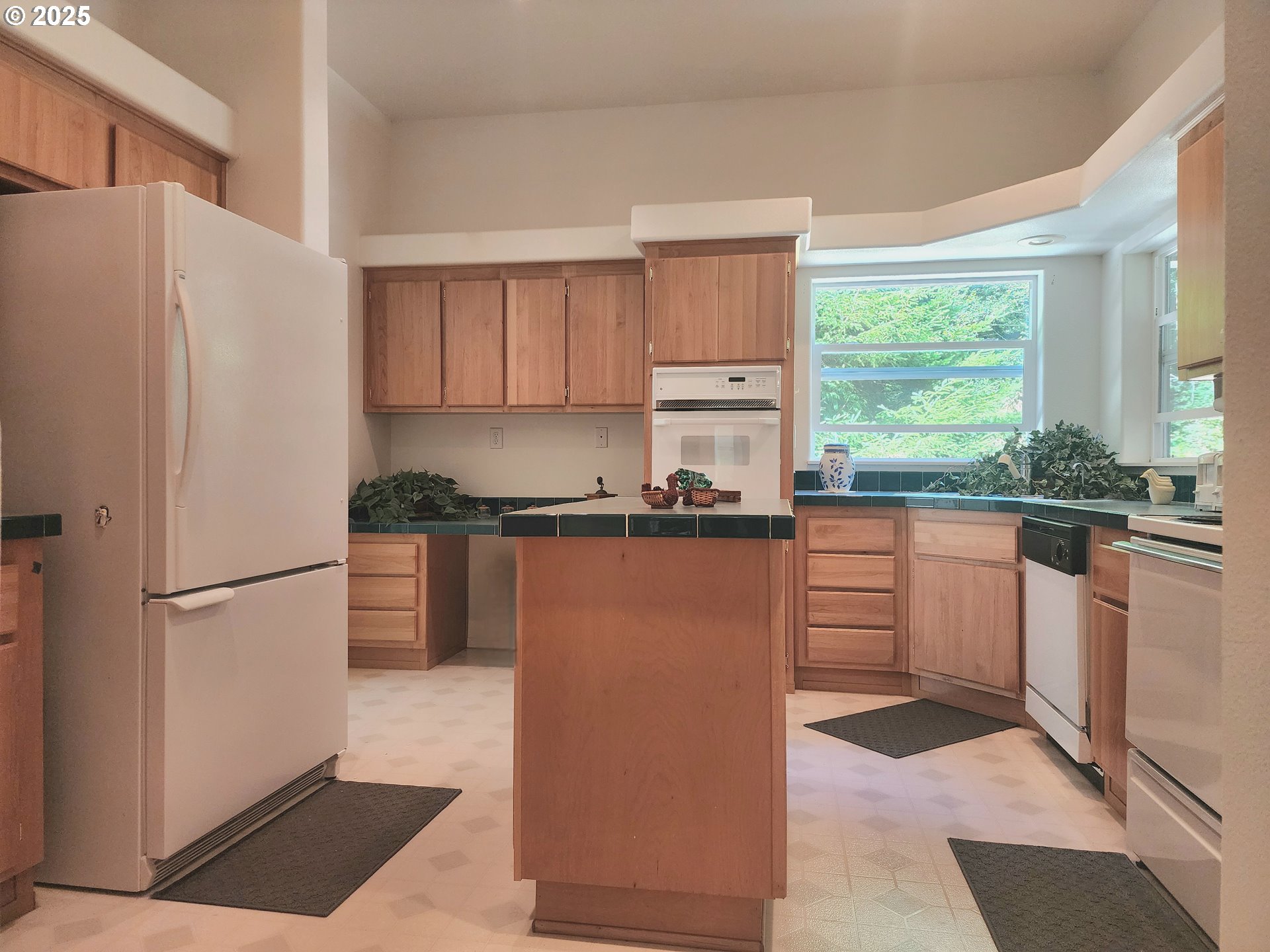 2647 South Tenmile Lakeside, OR 97449 - Photo 19 of 47 a kitchen with granite countertop a refrigerator a sink a stove and white cabinets