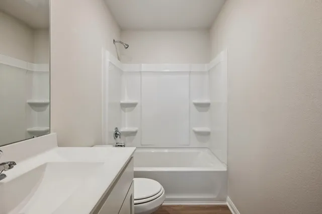 a bathroom with a bathtub shower sink vanity and toilet
