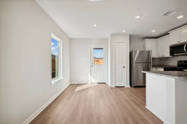 a kitchen with a refrigerator and a stove top oven