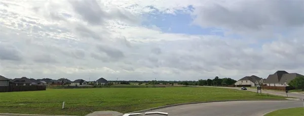 a view of a city with green space and wooden fence