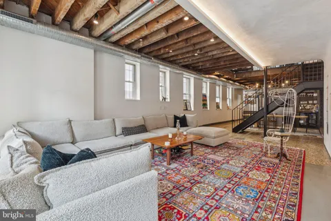 a living room with furniture a wooden floor and a rug