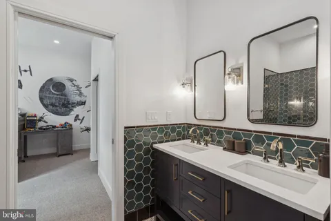 a en suite bathroom with a double vanity sink and a mirror