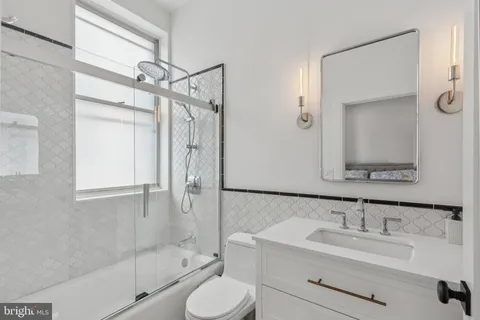 a bathroom with a sink toilet a mirror and shower