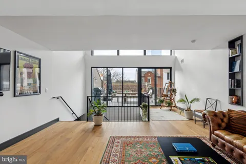 a living room with furniture a rug and a floor to ceiling window