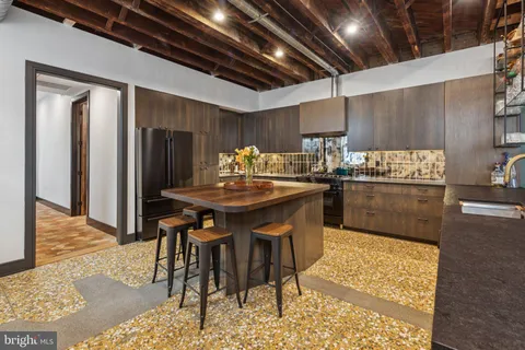 a kitchen with stainless steel appliances kitchen island granite countertop a table chairs sink and cabinets