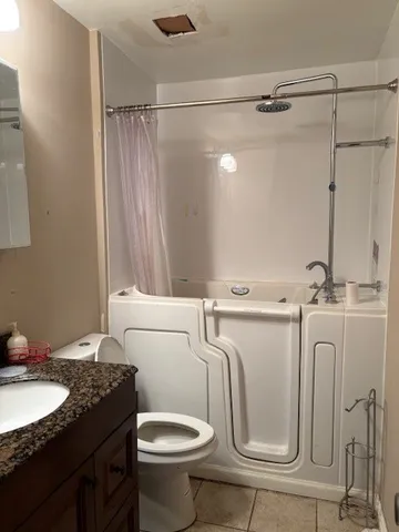 a bathroom with a granite countertop sink toilet and shower