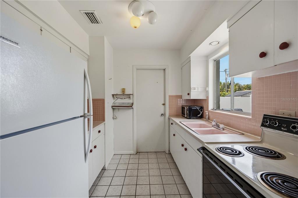309 Base Avenue East Venice, FL 34285 - Photo 15 of 36 a kitchen with a refrigerator and a stove top oven