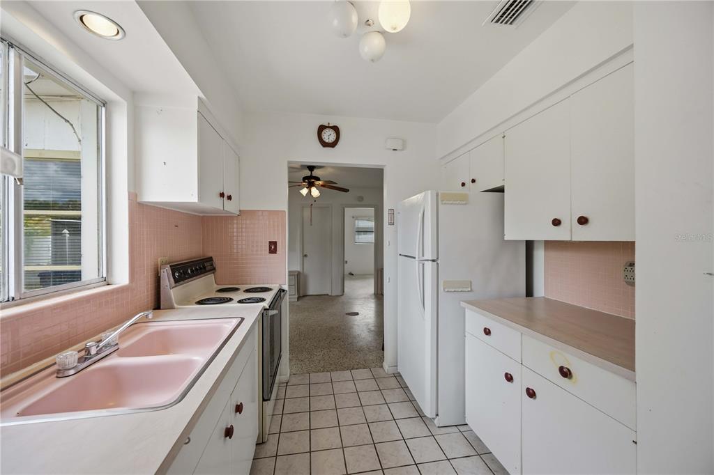 309 Base Avenue East Venice, FL 34285 - Photo 16 of 36 a kitchen with granite countertop a sink stove and refrigerator