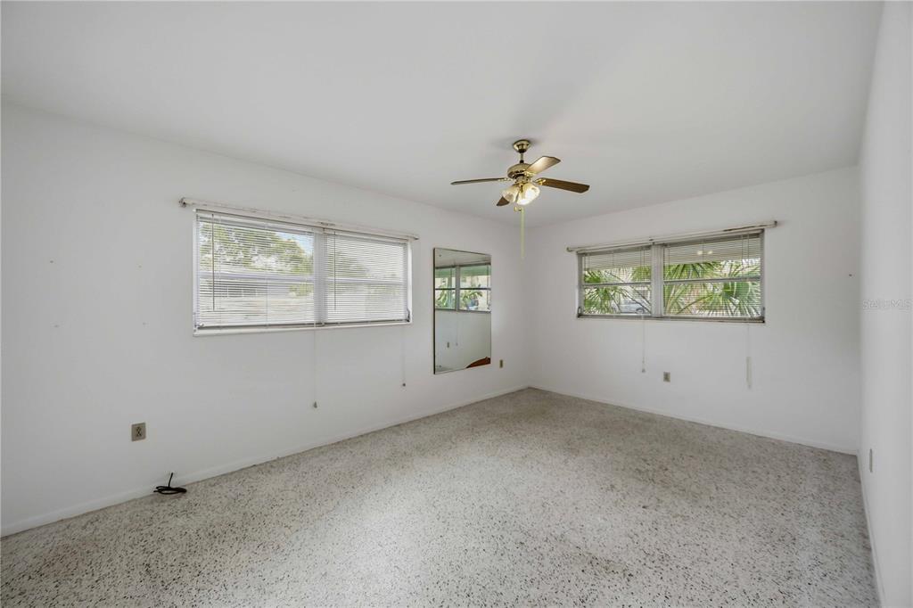 309 Base Avenue East Venice, FL 34285 - Photo 17 of 36 an empty room with windows and chandelier fan