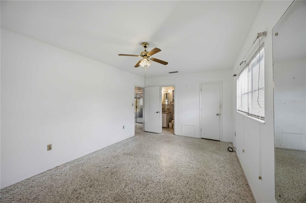 309 Base Avenue East Venice, FL 34285 - Photo 19 of 36 an empty room with chandelier fan and windows