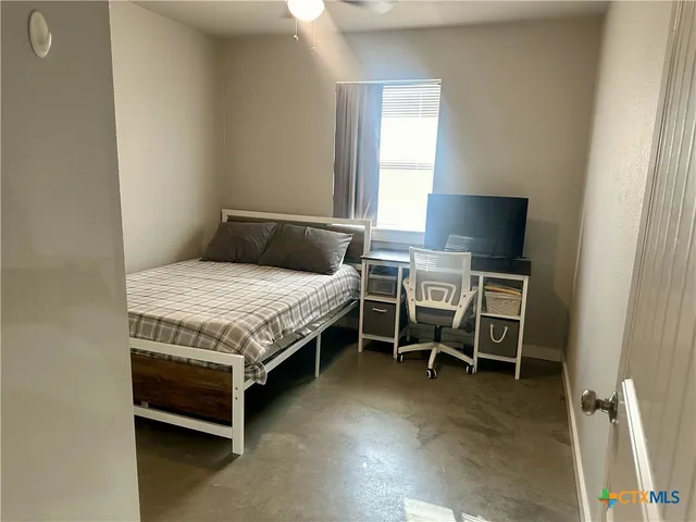 a bedroom with a bed and a potted plant