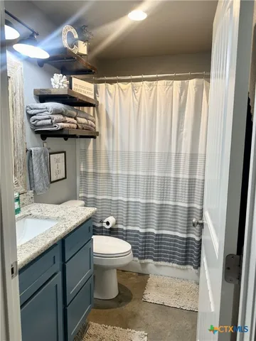 a kitchen with stainless steel appliances granite countertop a sink dishwasher a refrigerator white cabinets and wooden floor