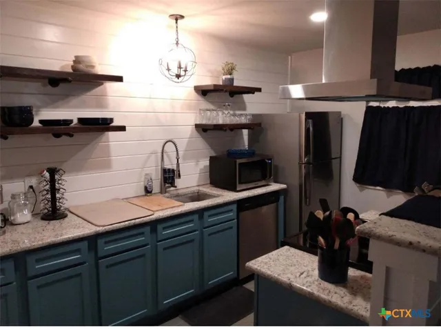 a kitchen with cabinets a sink and appliances