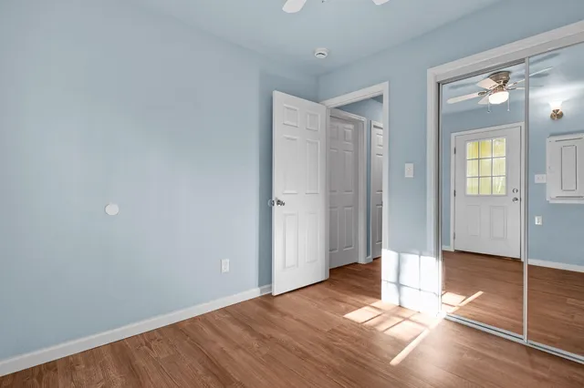 an empty room with wooden floor and windows