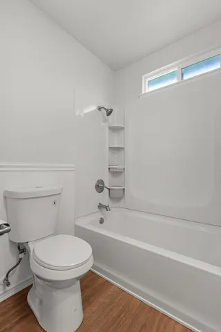 a bathroom with a toilet and a bath tub