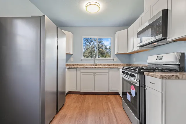 a kitchen with stainless steel appliances granite countertop a stove and a refrigerator
