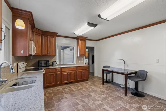 a kitchen with granite countertop a sink and cabinets