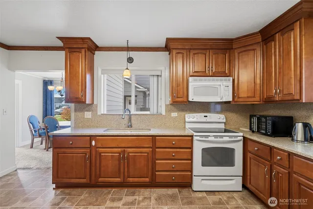 a kitchen with stainless steel appliances granite countertop a stove a sink and a microwave