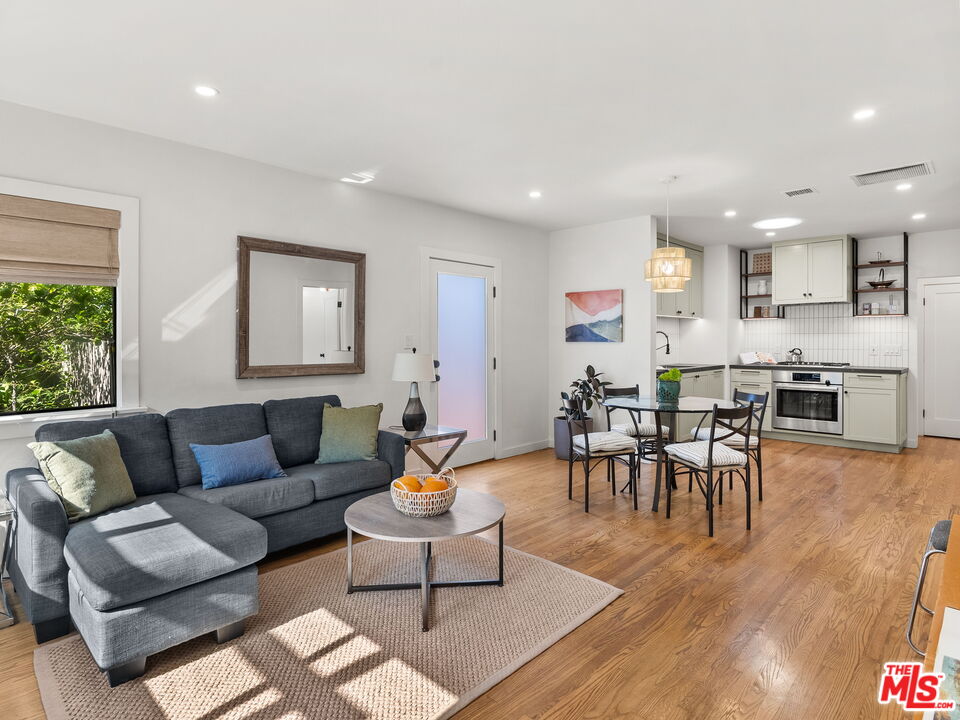 4707 Toland Way Los Angeles, CA 90042 - Photo 3 of 31 a living room with furniture and a dining table with wooden floor