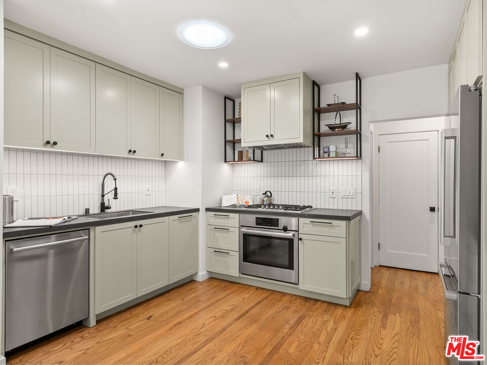 4707 Toland Way Los Angeles, CA 90042 - Photo 7 of 31 a kitchen with stainless steel appliances granite countertop a sink stove and refrigerator