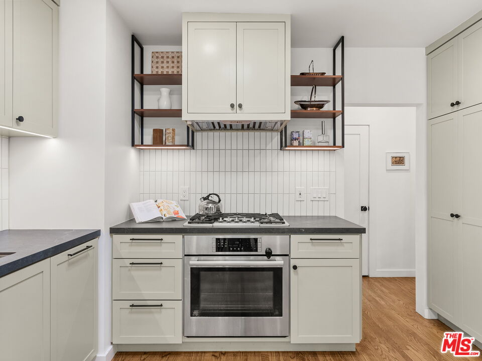 4707 Toland Way Los Angeles, CA 90042 - Photo 9 of 31 a kitchen with cabinets stainless steel appliances and wooden floor