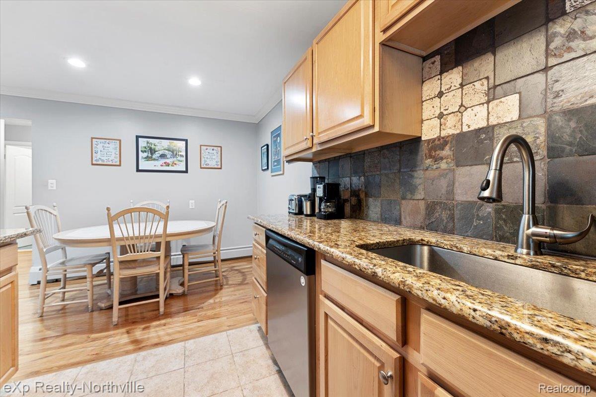 475 South Adams Road Birmingham, MI 48009 - Photo 11 of 23 Kitchen featuring light wood finish cabinetry, light stone countertops, dishwasher, crown molding, and decorative backsplash