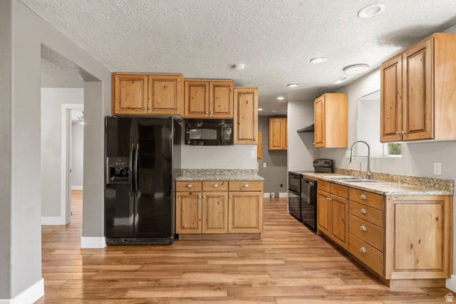 55 Spring Drive Toquerville, UT 84774 - Photo 11 of 36 Kitchen featuring black appliances, light stone counters, light wood-style floors, recessed lighting, and a textured ceiling