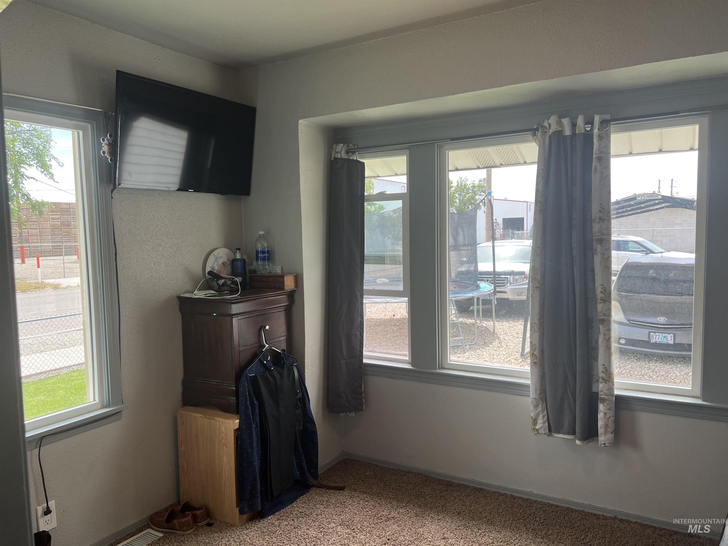 121 North 1st Street Nyssa, OR 97913 - Photo 14 of 20 Carpeted interior space featuring a multi-paned window wall with a window seat ledge, complemented by an additional single-pane window