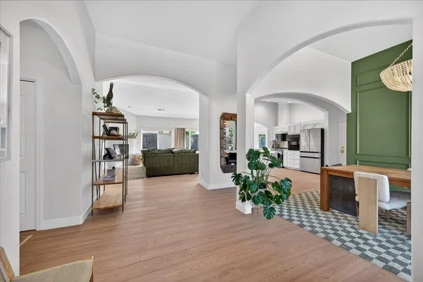 a dining room with furniture a chandelier and wooden floor
