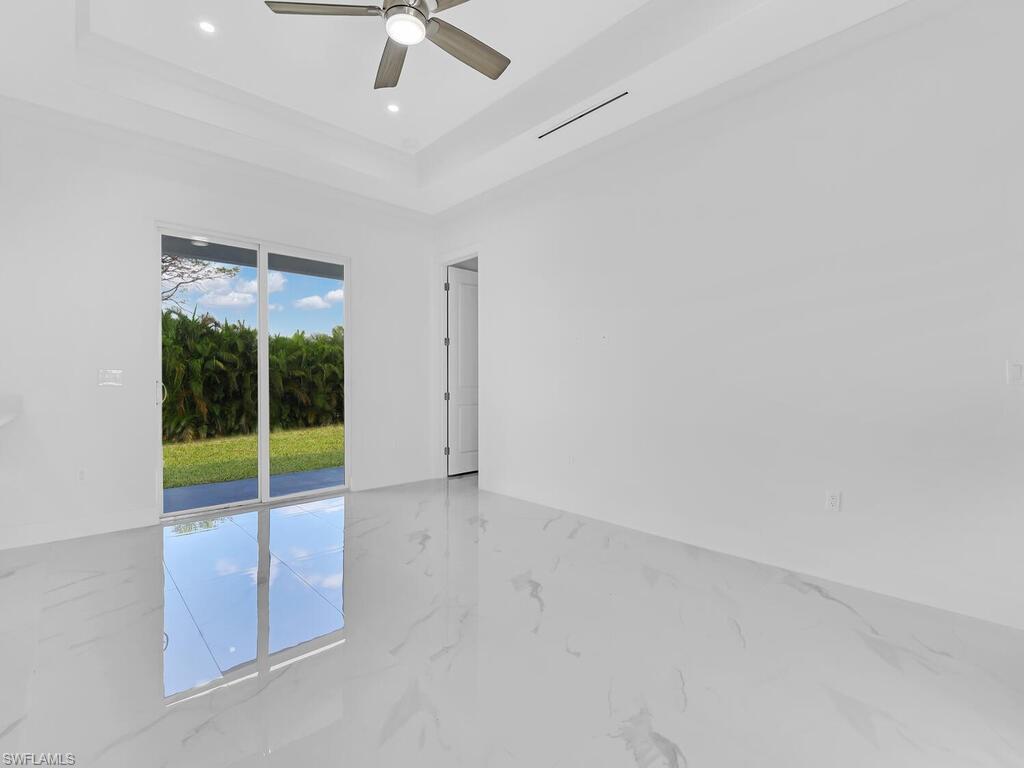 6108 Stratton Road Fort Myers, FL 33905 - Photo 11 of 27 Unfurnished room featuring a tray ceiling, marble tiled floors, ceiling fan, and recessed lighting