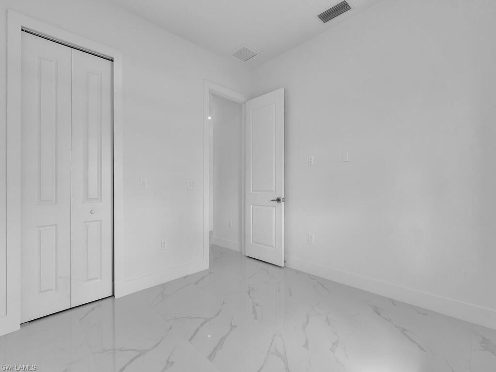 6108 Stratton Road Fort Myers, FL 33905 - Photo 18 of 27 Unfurnished bedroom featuring marble look tiles and a closet