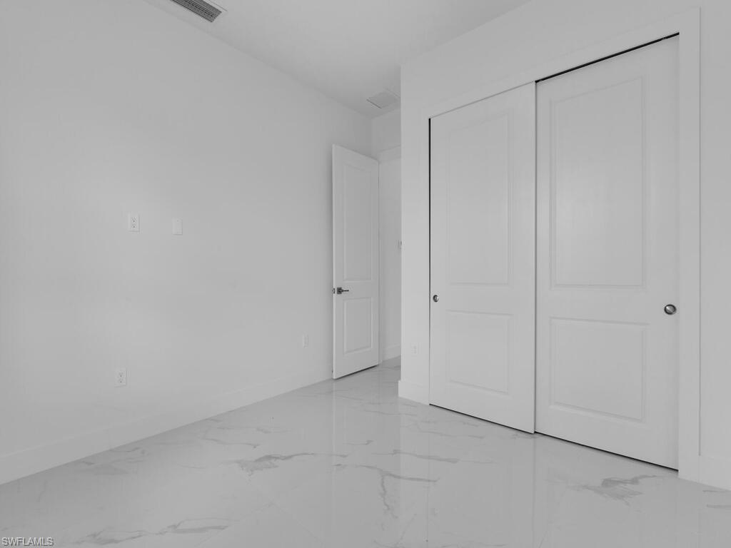 6108 Stratton Road Fort Myers, FL 33905 - Photo 23 of 27 Unfurnished bedroom featuring light marble finish flooring and a closet