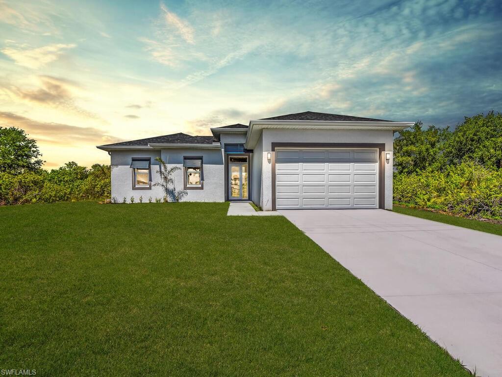 6108 Stratton Road Fort Myers, FL 33905 - Photo 6 of 27 New construction house with an attached garage, concrete driveway, stucco siding, and a yard