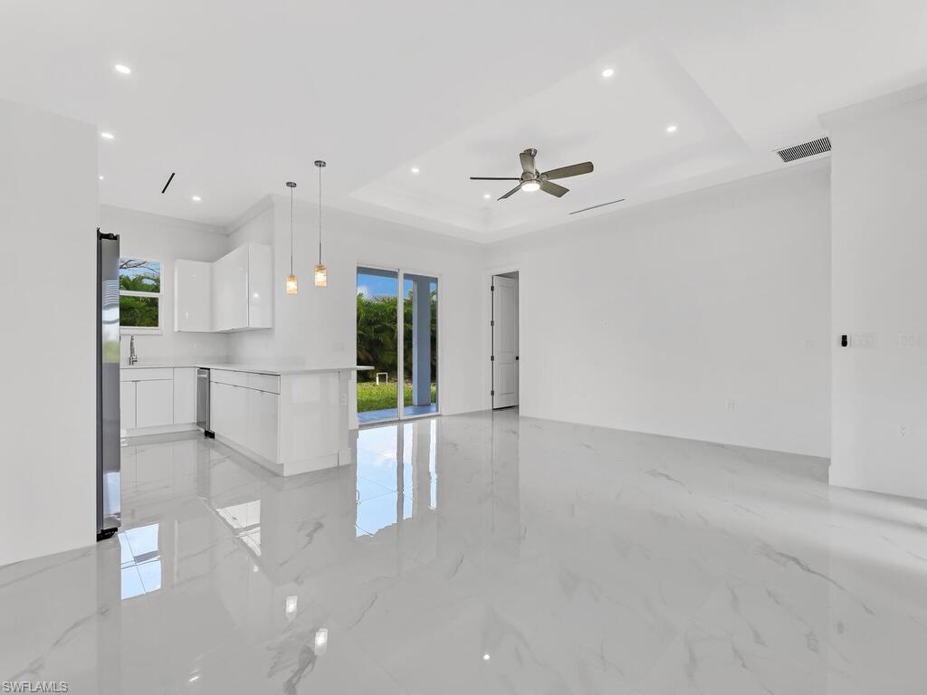 6108 Stratton Road Fort Myers, FL 33905 - Photo 9 of 27 Unfurnished room featuring a tray ceiling, light marble finish flooring, recessed lighting, and ceiling fan